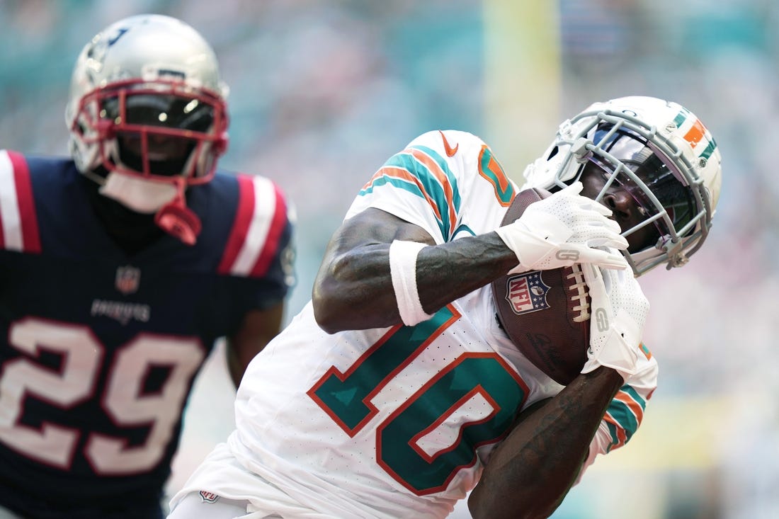 Miami Dolphins wide receiver Tyreek Hill (10) catches a touchdown over New England Patriots cornerback J.C. Jackson (29) during the first half of an NFL game at Hard Rock Stadium in Miami Gardens, Oct. 29, 2023.