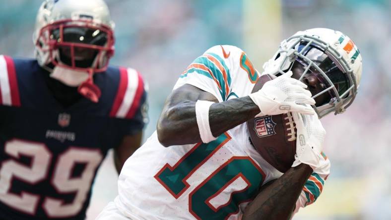 Miami Dolphins wide receiver Tyreek Hill (10) catches a touchdown over New England Patriots cornerback J.C. Jackson (29) during the first half of an NFL game at Hard Rock Stadium in Miami Gardens, Oct. 29, 2023.