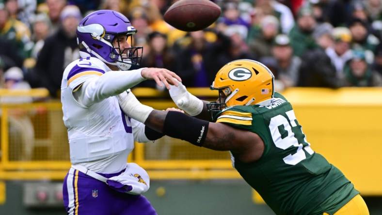 Oct 29, 2023; Green Bay, Wisconsin, USA; Minnesota Vikings quarterback Kirk Cousins (8) gets a pass away while under pressure from Green Bay Packers linebacker Kenny Clark (97) in the first quarter at Lambeau Field. Mandatory Credit: Benny Sieu-USA TODAY Sports