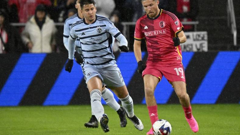 Oct 29, 2023; St. Louis, MO, USA; St. Louis City midfielder Indiana Vassilev (19) dribbles against Sporting Kansas City midfielder Nemanja Radoja (6) in the first half of game one in a round one match of the 2023 MLS Cup Playoffs at CITYPARK. Mandatory Credit: Scott Rovak-USA TODAY Sports