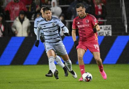Oct 29, 2023; St. Louis, MO, USA; St. Louis City midfielder Indiana Vassilev (19) dribbles against Sporting Kansas City midfielder Nemanja Radoja (6) in the first half of game one in a round one match of the 2023 MLS Cup Playoffs at CITYPARK. Mandatory Credit: Scott Rovak-USA TODAY Sports