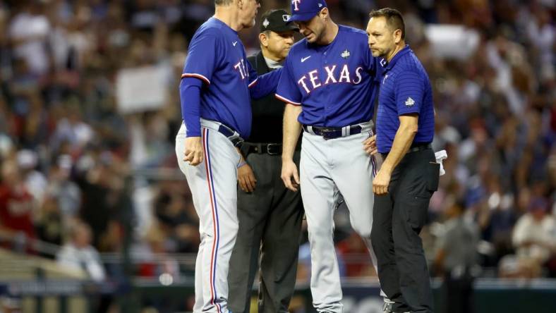 Oct 30, 2023; Phoenix, AZ, USA; Texas Rangers pitcher Max Scherzer (31) talks to manager Bruce Bochy (15) and a trainer before leaving the game in the fourth inning in game three of the 2023 World Series against the Arizona Diamondbacks at Chase Field. Mandatory Credit: Mark J. Rebilas-USA TODAY Sports