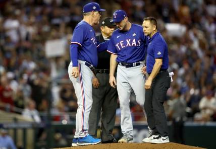 Oct 30, 2023; Phoenix, AZ, USA; Texas Rangers pitcher Max Scherzer (31) talks to manager Bruce Bochy (15) and a trainer before leaving the game in the fourth inning in game three of the 2023 World Series against the Arizona Diamondbacks at Chase Field. Mandatory Credit: Mark J. Rebilas-USA TODAY Sports