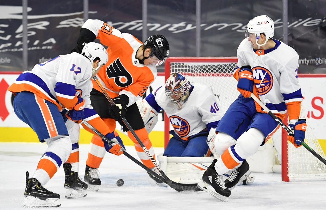 Jan 30, 2021; Philadelphia, Pennsylvania, USA; Philadelphia Flyers left wing Oskar Lindblom (23) battles for the puck with New York Islanders left wing Matt Martin (17) and defenseman Adam Pelech (3) in front of goaltender Semyon Varlamov (40) during the second period at Wells Fargo Center. Mandatory Credit: Eric Hartline-USA TODAY Sports