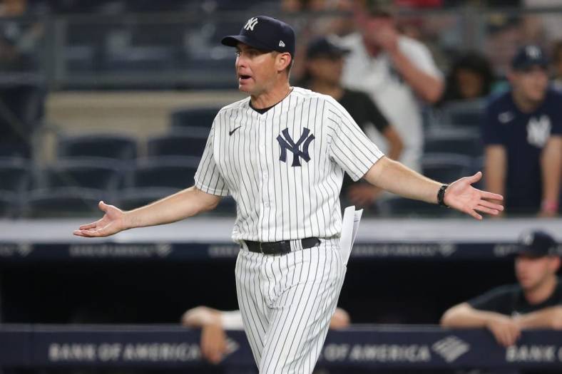 Jun 6, 2021; Bronx, New York, USA; New York Yankees bench coach Carlos Mendoza (64) reacts after being ejected during the tenth inning against the Boston Red Sox at Yankee Stadium. Mandatory Credit: Brad Penner-USA TODAY Sports