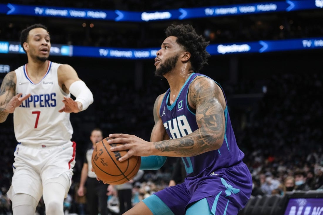 Jan 30, 2022; Charlotte, North Carolina, USA; Charlotte Hornets forward Miles Bridges (0) pulls up for a jumper defended by LA Clippers guard Amir Coffey (7) during the second quarter at the Spectrum Center. Mandatory Credit: Jim Dedmon-USA TODAY Sports