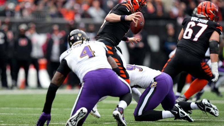 Jan 8, 2023; Cincinnati, Ohio, USA; Cincinnati Bengals quarterback Joe Burrow (9) avoids pressure by Baltimore Ravens linebacker Jason Pierre-Paul (4) in the first quarter at Paycor Stadium. Mandatory Credit: Kareem Elgazzar-USA TODAY Sports