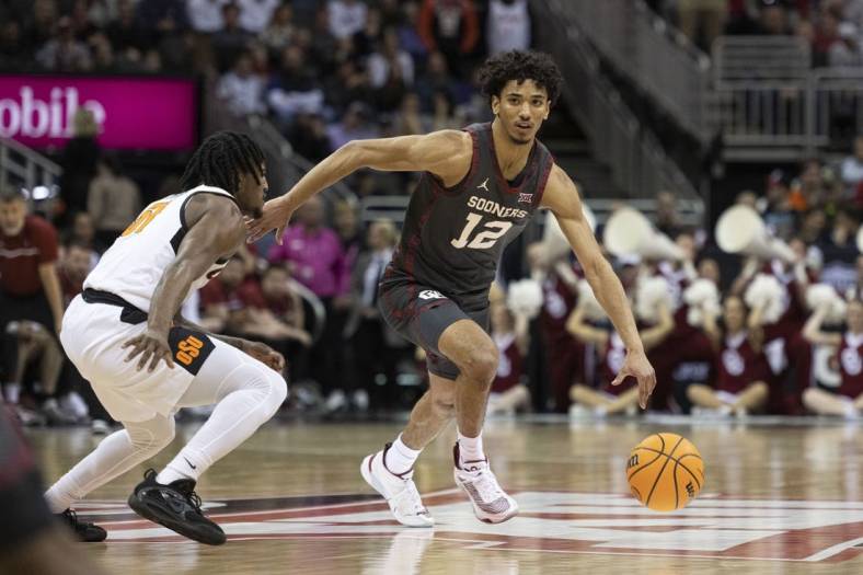 Mar 8, 2023; Kansas City, MO, USA; Oklahoma Sooners guard Milos Uzan (12) dribbles the ball while defended by Oklahoma State Cowboys guard John-Michael Wright (51) in the first half at T-Mobile Center. Mandatory Credit: Amy Kontras-USA TODAY Sports