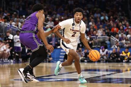 Mar 16, 2023; Orlando, FL, USA; Virginia Cavaliers guard Reece Beekman (2) dribbles the ball while defended by Furman Paladins guard Marcus Foster (5) during the second half at Amway Center. Mandatory Credit: Matt Pendleton-USA TODAY Sports