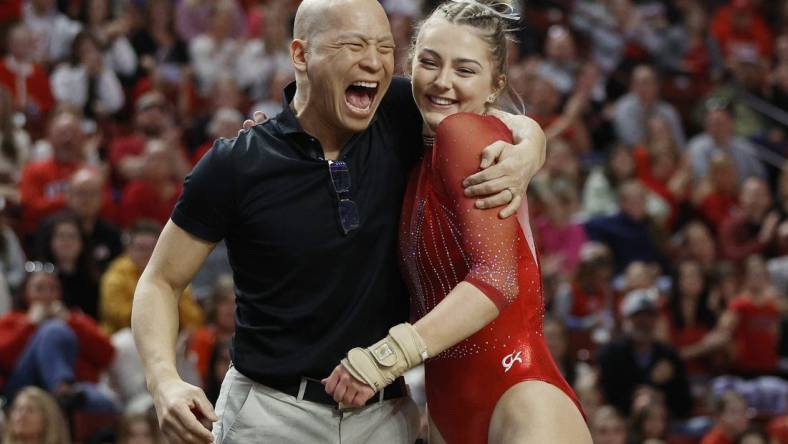 Mar 18, 2023; West Valley City, UT, USA; Utah s head gymnastics coach Tom Farden celebrates with Lucy Stanhope after her vault during the Pac-12 Women's Gymnastics Championship at Maverik Center. Mandatory Credit: Jeffrey Swinger-USA TODAY Sports