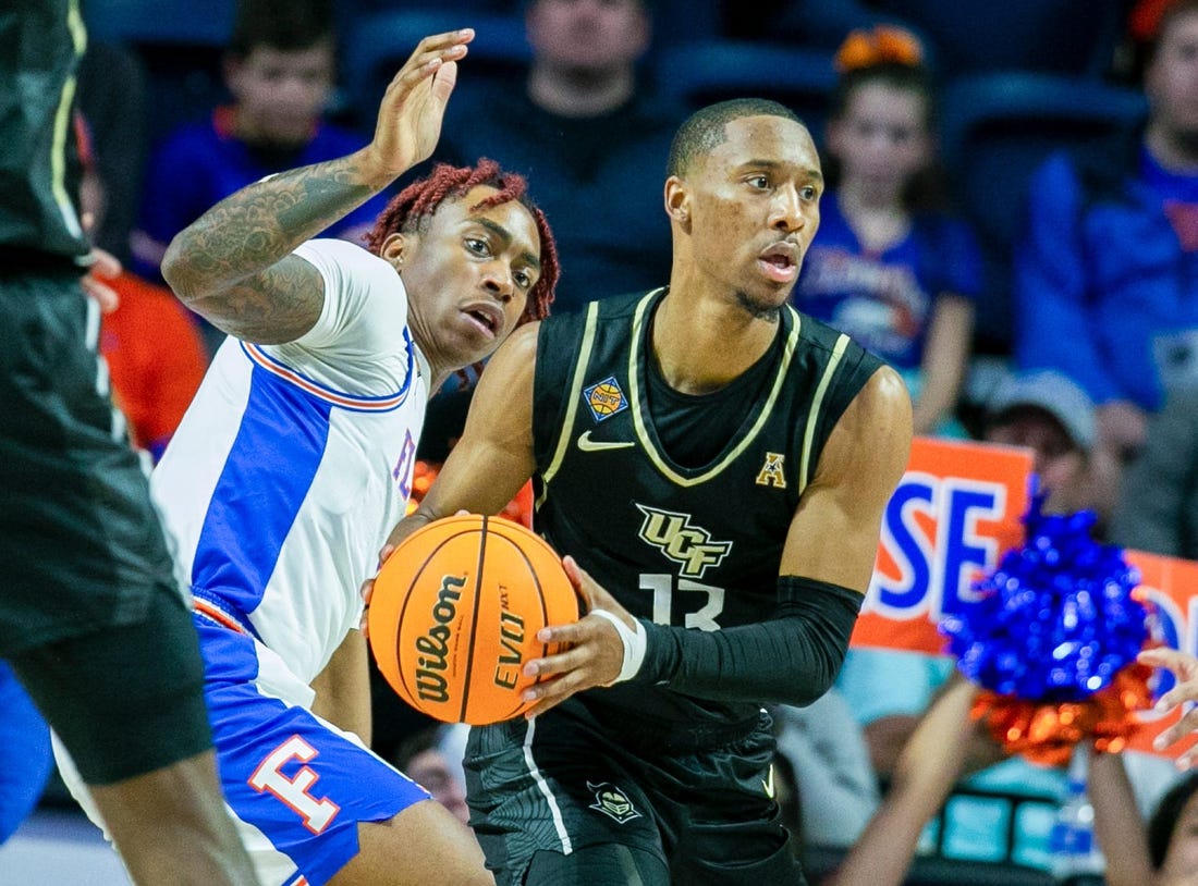 Florida Gators guard Niels Lane (4) tries to get the ball from UCF Knights guard C.J. Kelly (13) during the second half of the NIT tournament Wednesday, March 15, 2023, at Exactech Arena in Gainesville, Fla. Florida lost to UCF 67-49. Alan Youngblood/Gainesville Sun

Gai Ufucf3takeaways2 315753925416