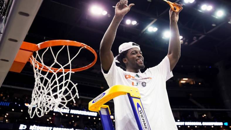 Mar 26, 2023; Kansas City, MO, USA; Miami (Fl) Hurricanes guard Bensley Joseph (4) cuts down the net after defeating the Texas Longhorns in an Elite 8 college basketball game in the Midwest Regional of the 2023 NCAA Tournament at T-Mobile Center. Mandatory Credit: Jay Biggerstaff-USA TODAY Sports