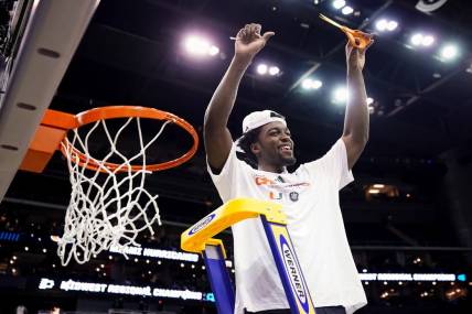 Mar 26, 2023; Kansas City, MO, USA; Miami (Fl) Hurricanes guard Bensley Joseph (4) cuts down the net after defeating the Texas Longhorns in an Elite 8 college basketball game in the Midwest Regional of the 2023 NCAA Tournament at T-Mobile Center. Mandatory Credit: Jay Biggerstaff-USA TODAY Sports