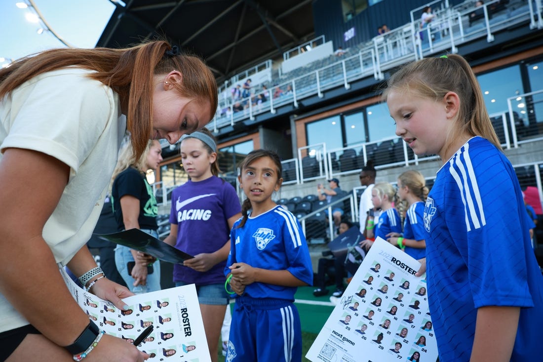 Sep 15, 2023; Louisville, Kentucky, USA; Racing Louisville FC goalkeeper Jordyn Bloomer (24) signs autographs before the match against the Houston Dash at Lynn Family Stadium. Mandatory Credit: EM Dash-USA TODAY Sports