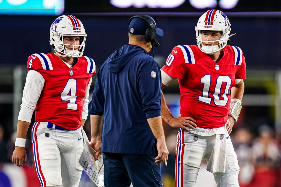 Sep 17, 2023; Foxborough, Massachusetts, USA; New England Patriots quarterback Mac Jones (10) and quarterback Bailey Zappe (4) talk with offensive coordinator/quarterbacks coach Bill O'Brien in the second quarter at Gillette Stadium. Mandatory Credit: David Butler II-USA TODAY Sports