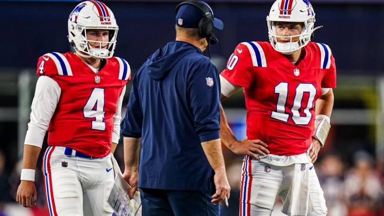 Sep 17, 2023; Foxborough, Massachusetts, USA; New England Patriots quarterback Mac Jones (10) and quarterback Bailey Zappe (4) talk with offensive coordinator/quarterbacks coach Bill O'Brien in the second quarter at Gillette Stadium. Mandatory Credit: David Butler II-USA TODAY Sports