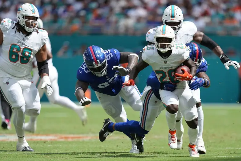 Miami Dolphins running back De'Von Achane (28) breaks free for a gain as New York Giants safety Isaiah Simmons (19) closes in on the play during the first half of an NFL game at Hard Rock Stadium in Miami Gardens, October 8, 2023.
