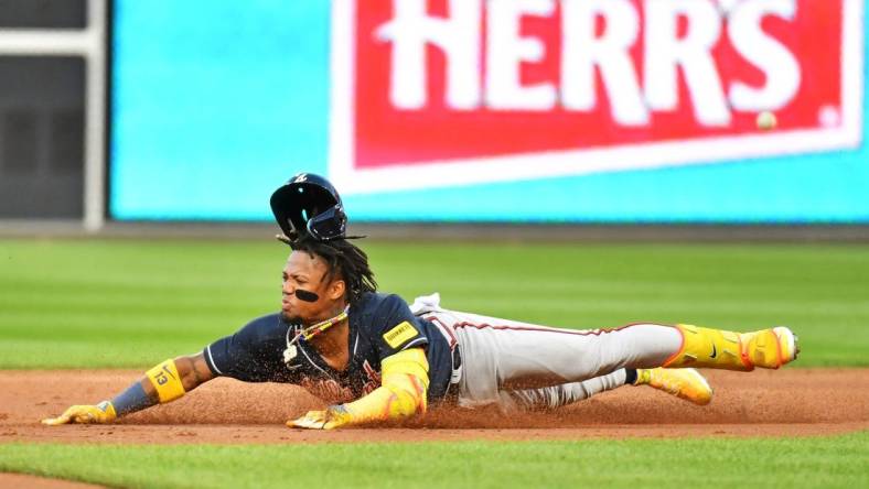 Oct 11, 2023; Philadelphia, Pennsylvania, USA;  Atlanta Braves right fielder Ronald Acuna Jr. (13) slides into second base for a double during the third inning against the Philadelphia Phillies in game three of the NLDS for the 2023 MLB playoffs at Citizens Bank Park. Mandatory Credit: Eric Hartline-USA TODAY Sports