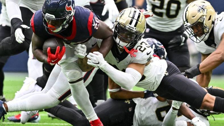 Oct 15, 2023; Houston, Texas, USA; New Orleans Saints cornerback Marshon Lattimore (23) tackles Houston Texans running back Devin Singletary (26) during the second quarter at NRG Stadium. Mandatory Credit: Maria Lysaker-USA TODAY Sports