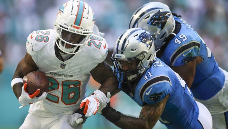 Oct 15, 2023; Miami Gardens, Florida, USA; Miami Dolphins running back De'Von Achane (28) runs with the football against Carolina Panthers safety Matthias Farley (41) during the fourth quarter at Hard Rock Stadium. Mandatory Credit: Sam Navarro-USA TODAY Sports