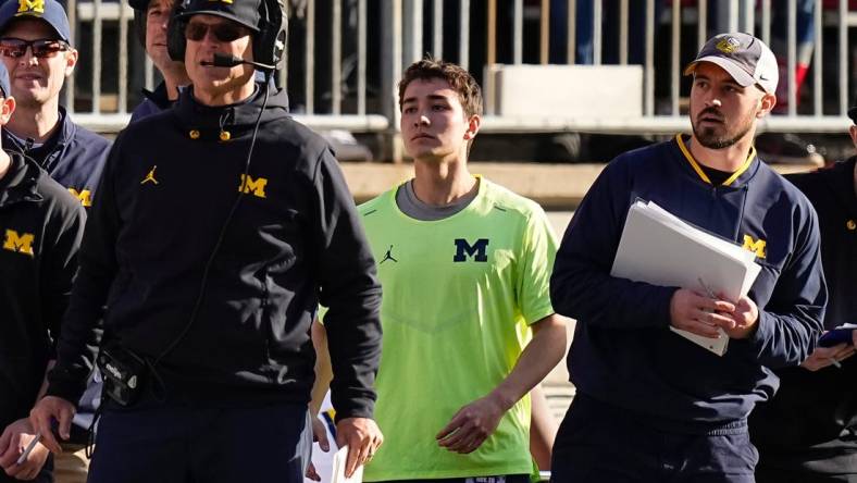 Nov 26, 2022; Columbus, Ohio, USA; Michigan Wolverines head coach Jim Harbaugh watches from the sideline beside off-field analyst Connor Stalions, right, during the NCAA football game against the Ohio State Buckeyes at Ohio Stadium.