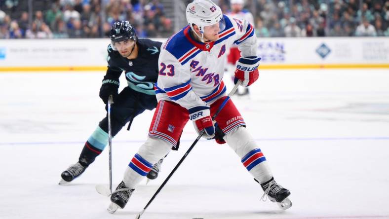 Oct 21, 2023; Seattle, Washington, USA; New York Rangers defenseman Adam Fox (23) plays the puck during the third period against the New York Rangers at Climate Pledge Arena. Mandatory Credit: Steven Bisig-USA TODAY Sports