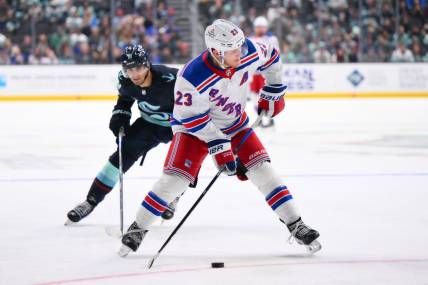 Oct 21, 2023; Seattle, Washington, USA; New York Rangers defenseman Adam Fox (23) plays the puck during the third period against the New York Rangers at Climate Pledge Arena. Mandatory Credit: Steven Bisig-USA TODAY Sports