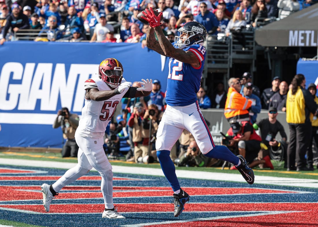 Oct 22, 2023; East Rutherford, New Jersey, USA; New York Giants tight end Darren Waller (12) catches a touchdown pass during the first half in front of Washington Commanders linebacker Jamin Davis (52) at MetLife Stadium. Mandatory Credit: Vincent Carchietta-USA TODAY Sports