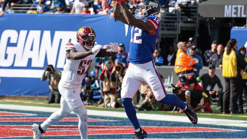 Oct 22, 2023; East Rutherford, New Jersey, USA; New York Giants tight end Darren Waller (12) catches a touchdown pass during the first half in front of Washington Commanders linebacker Jamin Davis (52) at MetLife Stadium. Mandatory Credit: Vincent Carchietta-USA TODAY Sports