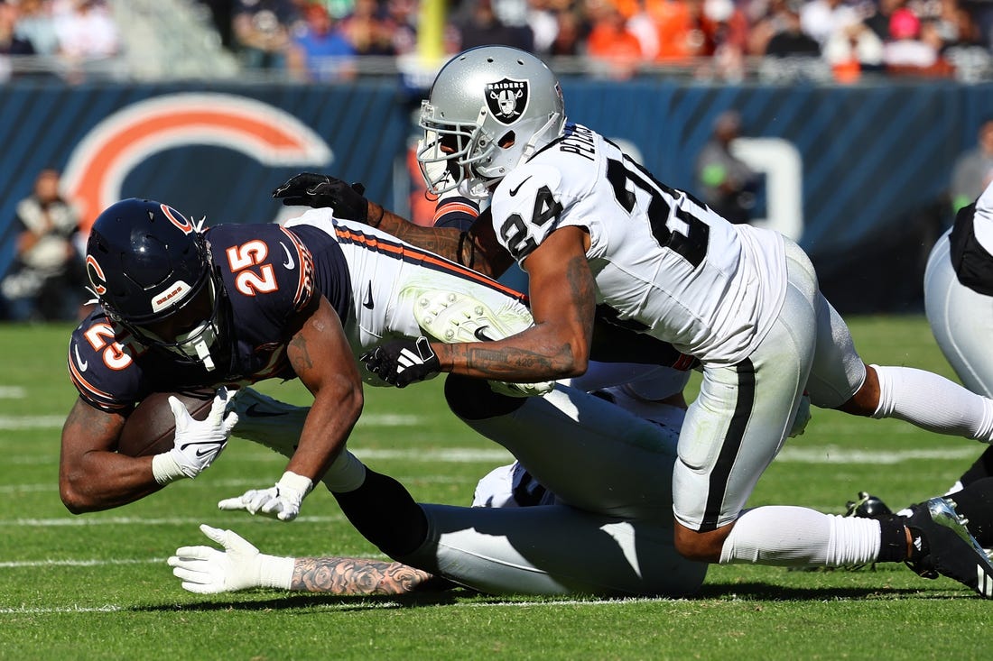 Oct 22, 2023; Chicago, Illinois, USA; Chicago Bears running back Darrynton Evans (25) rushes the ball against Las Vegas Raiders cornerback Marcus Peters (24) in the second half at Soldier Field. Mandatory Credit: Mike Dinovo-USA TODAY Sports