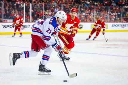 Oct 24, 2023; Calgary, Alberta, CAN; New York Rangers defenseman Adam Fox (23) skates with the puck against the Calgary Flames during the second period at Scotiabank Saddledome. Mandatory Credit: Sergei Belski-USA TODAY Sports