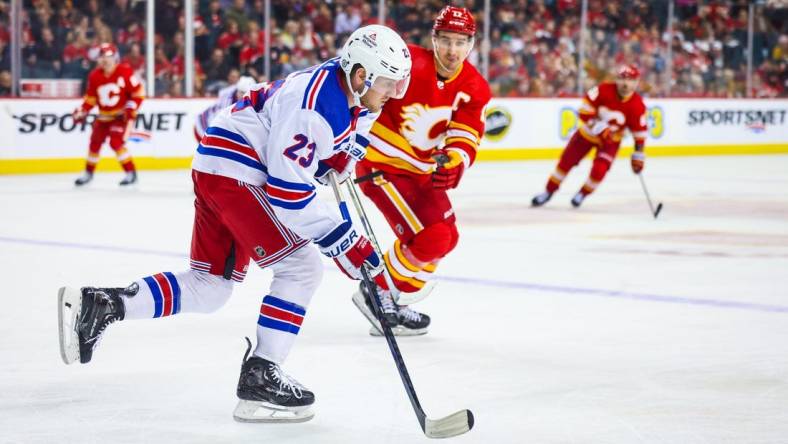 Oct 24, 2023; Calgary, Alberta, CAN; New York Rangers defenseman Adam Fox (23) skates with the puck against the Calgary Flames during the second period at Scotiabank Saddledome. Mandatory Credit: Sergei Belski-USA TODAY Sports