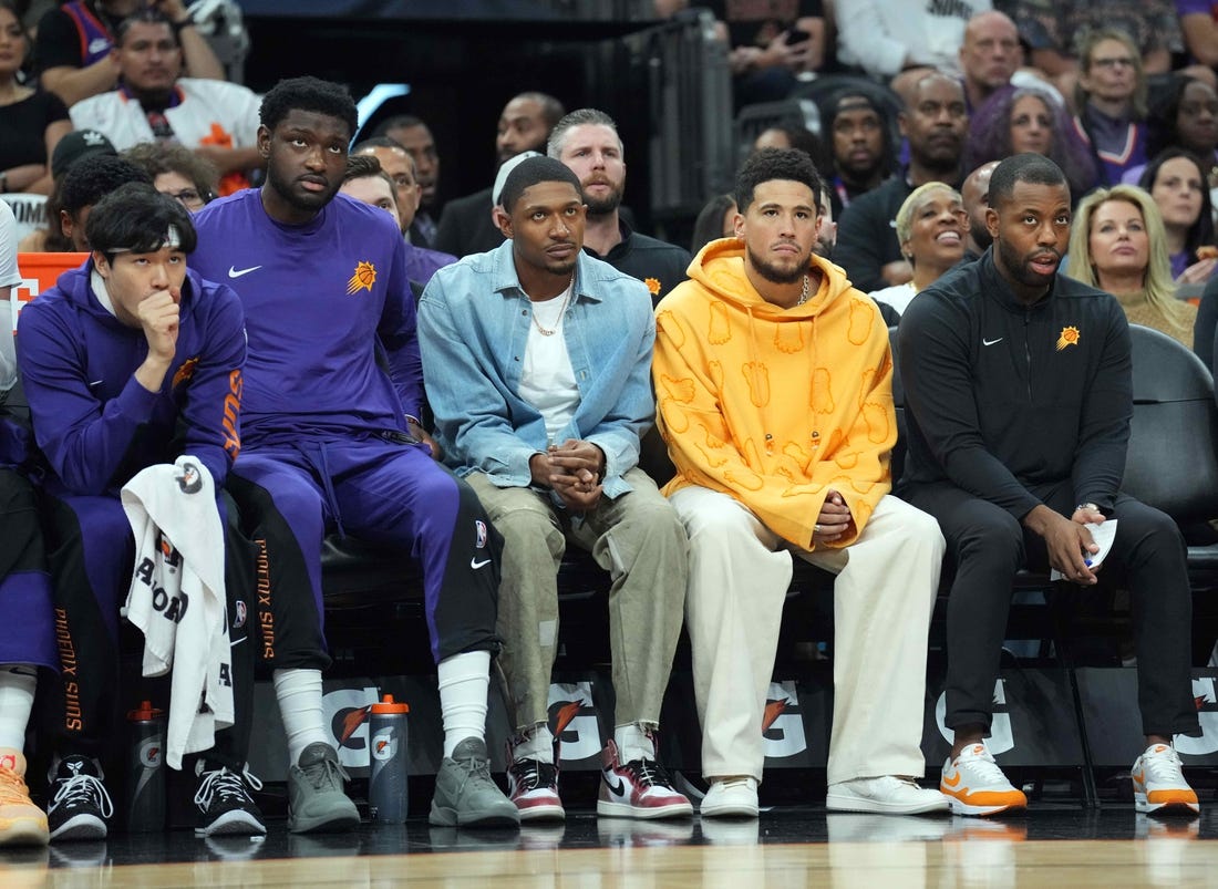 Oct 28, 2023; Phoenix, Arizona, USA; Bradley Beal (blue shirt) and Devin Booker (orange shirt) look on against the Utah Jazz during the first half at Footprint Center. Mandatory Credit: Joe Camporeale-USA TODAY Sports