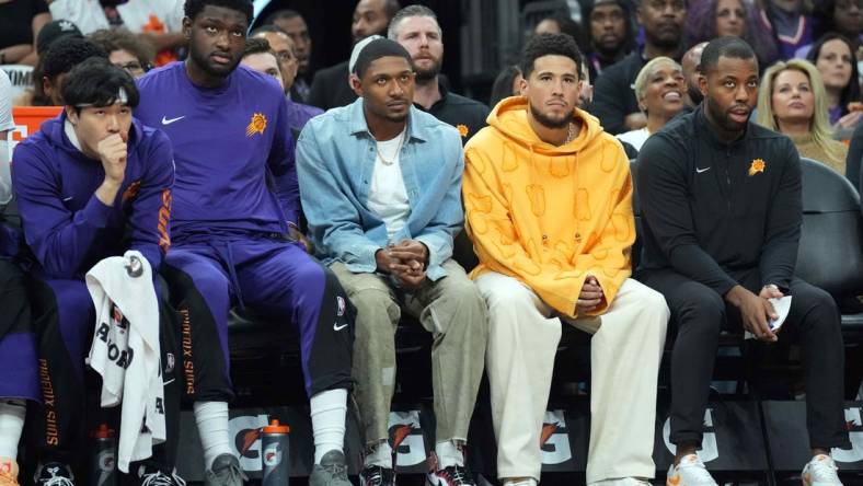 Oct 28, 2023; Phoenix, Arizona, USA; Bradley Beal (blue shirt) and Devin Booker (orange shirt) look on against the Utah Jazz during the first half at Footprint Center. Mandatory Credit: Joe Camporeale-USA TODAY Sports