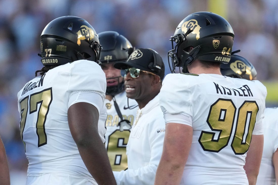 Oct 28, 2023; Pasadena, California, USA; Colorado Buffaloes head coach Deion Sanders talks with offensive tackle Kareem Harden (77) in the first half against the UCLA Bruins at Rose Bowl. Mandatory Credit: Kirby Lee-USA TODAY Sports