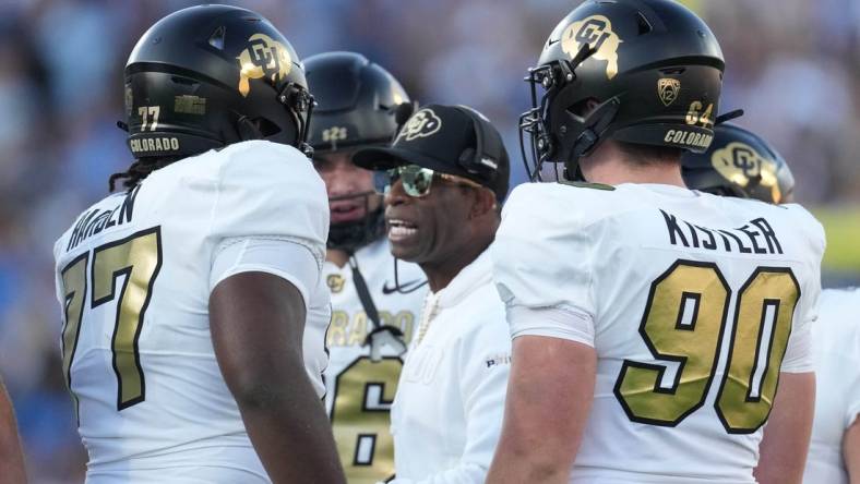 Oct 28, 2023; Pasadena, California, USA; Colorado Buffaloes head coach Deion Sanders talks with offensive tackle Kareem Harden (77) in the first half against the UCLA Bruins at Rose Bowl. Mandatory Credit: Kirby Lee-USA TODAY Sports