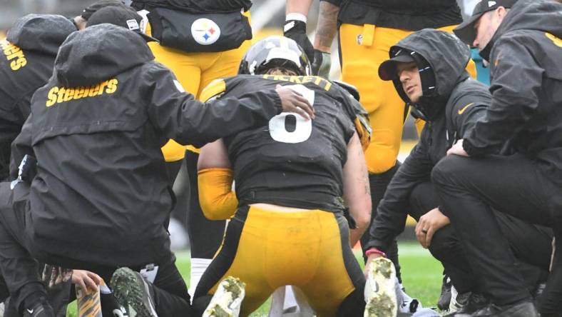 Oct 29, 2023; Pittsburgh, Pennsylvania, USA;  Pittsburgh Steelers quarterback Kenny Pickett (8) is tended to after taking a hit against the Jacksonville Jaguars during the second quarter at Acrisure Stadium. Mandatory Credit: Philip G. Pavely-USA TODAY Sports