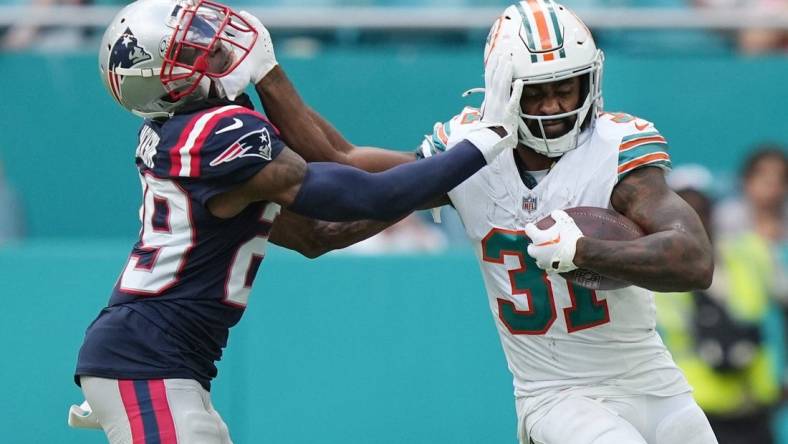 Miami Dolphins running back Raheem Mostert (31) stiff-arms New England Patriots cornerback J.C. Jackson (29) during the second half of an NFL game at Hard Rock Stadium in Miami Gardens, Oct. 29, 2023.