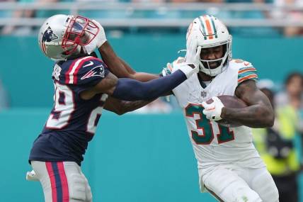 Miami Dolphins running back Raheem Mostert (31) stiff-arms New England Patriots cornerback J.C. Jackson (29) during the second half of an NFL game at Hard Rock Stadium in Miami Gardens, Oct. 29, 2023.