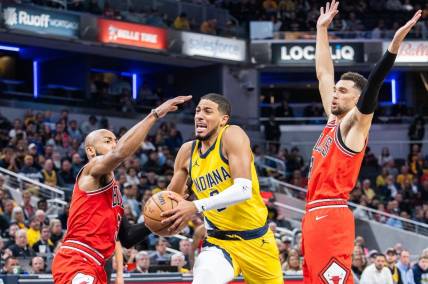 Oct 30, 2023; Indianapolis, Indiana, USA; Indiana Pacers guard Tyrese Haliburton (0) dribbles the ball while Chicago Bulls guard Jevon Carter (5) and guard Zach LaVine (8) defend in the second half at Gainbridge Fieldhouse. Mandatory Credit: Trevor Ruszkowski-USA TODAY Sports
