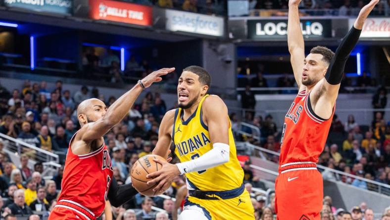 Oct 30, 2023; Indianapolis, Indiana, USA; Indiana Pacers guard Tyrese Haliburton (0) dribbles the ball while Chicago Bulls guard Jevon Carter (5) and guard Zach LaVine (8) defend in the second half at Gainbridge Fieldhouse. Mandatory Credit: Trevor Ruszkowski-USA TODAY Sports