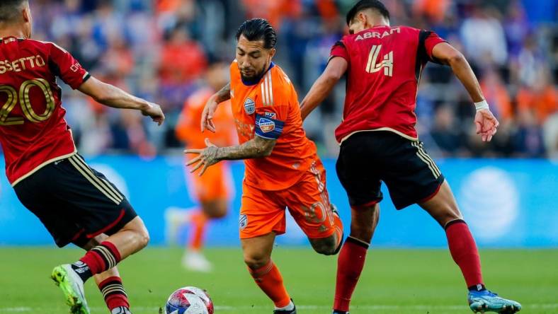 Oct 21, 2023; Cincinnati, Ohio, USA; FC Cincinnati midfielder Luciano Acosta (10) battles for the ball against Atlanta United FC midfielder Matheus Rossetto (20) and defender Luis Abram (4) in the first half at TQL Stadium. Mandatory Credit: Katie Stratman-USA TODAY Sports