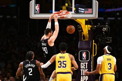 Nov 1, 2023; Los Angeles, California, USA;  LA Clippers center Ivica Zubac (40) dunks the ball against Los Angeles Lakers forward Christian Wood (35) and guard D'Angelo Russell (1) during the first quarter at Crypto.com Arena. Mandatory Credit: Jonathan Hui-USA TODAY Sports