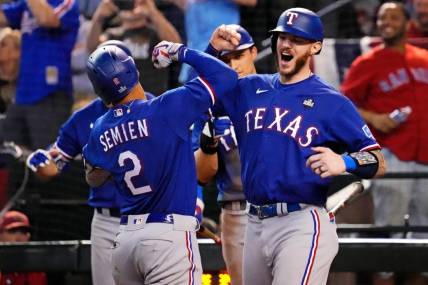 Texas Rangers second baseman Marcus Semien (2) celebrates with shortstop Corey Seager (5) after hitting a two run home run during the ninth inning against the Arizona Diamondbacks during game five of the 2023 World Series at Chase Field.