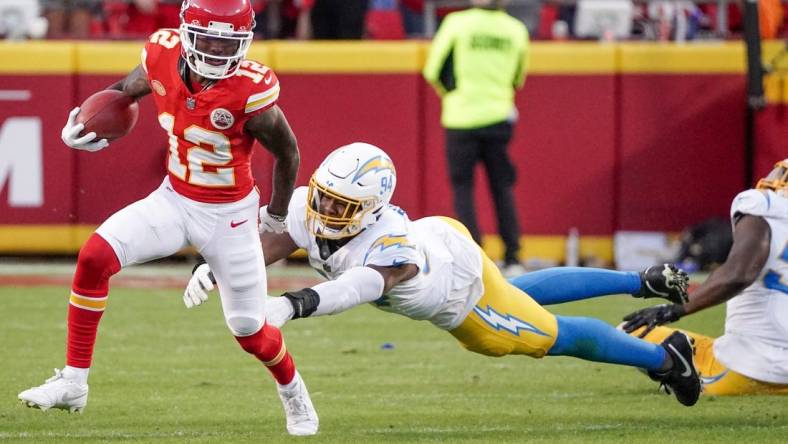 Oct 12, 2023; Kansas City, Missouri, USA; Kansas City Chiefs wide receiver Mecole Hardman Jr. (12) returns a kick as Los Angeles Chargers linebacker Chris Rumph II (94) attempts the tackle during the game at GEHA Field at Arrowhead Stadium. Mandatory Credit: Denny Medley-USA TODAY Sports