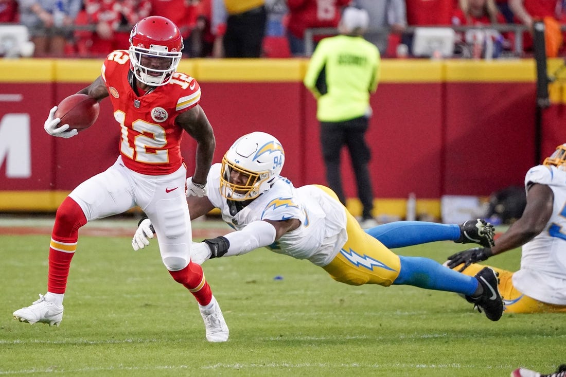 Oct 12, 2023; Kansas City, Missouri, USA; Kansas City Chiefs wide receiver Mecole Hardman Jr. (12) returns a kick as Los Angeles Chargers linebacker Chris Rumph II (94) attempts the tackle during the game at GEHA Field at Arrowhead Stadium. Mandatory Credit: Denny Medley-USA TODAY Sports