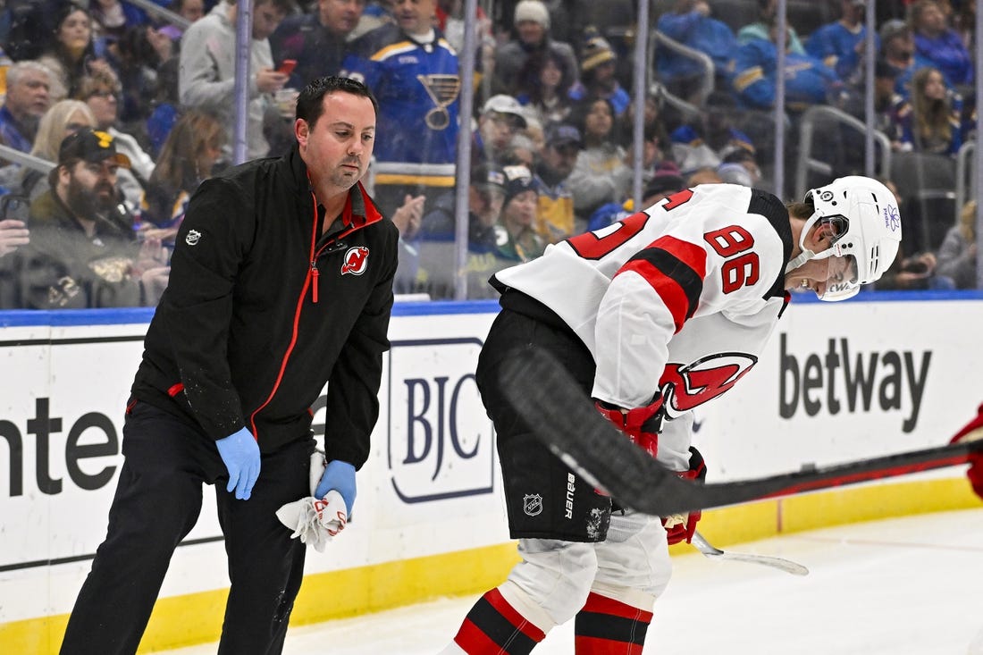 Nov 3, 2023; St. Louis, Missouri, USA;  New Jersey Devils center Jack Hughes (86) is checked on by a trainer after slamming in to the boards during the first period against the St. Louis Blues at Enterprise Center. Mandatory Credit: Jeff Curry-USA TODAY Sports