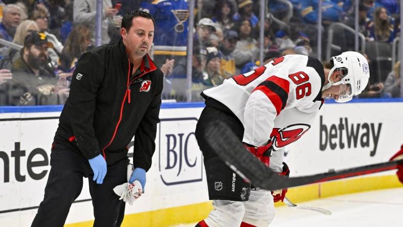 Nov 3, 2023; St. Louis, Missouri, USA;  New Jersey Devils center Jack Hughes (86) is checked on by a trainer after slamming in to the boards during the first period against the St. Louis Blues at Enterprise Center. Mandatory Credit: Jeff Curry-USA TODAY Sports