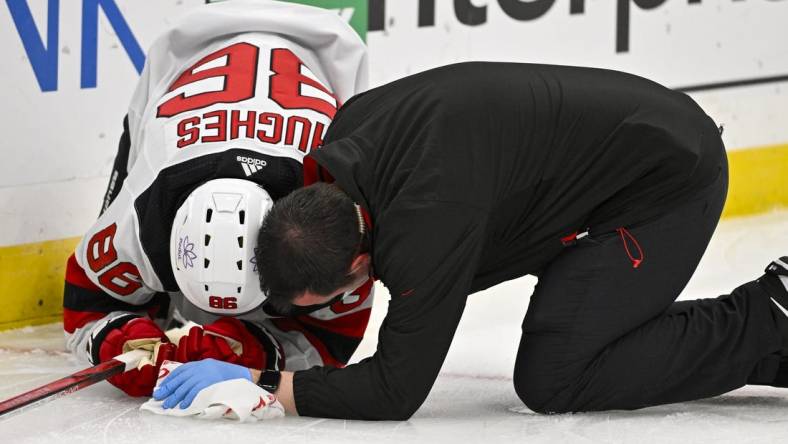 Nov 3, 2023; St. Louis, Missouri, USA;  New Jersey Devils center Jack Hughes (86) is checked on by a trainer after slamming in to the boards during the first period against the St. Louis Blues at Enterprise Center. Mandatory Credit: Jeff Curry-USA TODAY Sports