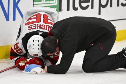 Nov 3, 2023; St. Louis, Missouri, USA;  New Jersey Devils center Jack Hughes (86) is checked on by a trainer after slamming in to the boards during the first period against the St. Louis Blues at Enterprise Center. Mandatory Credit: Jeff Curry-USA TODAY Sports